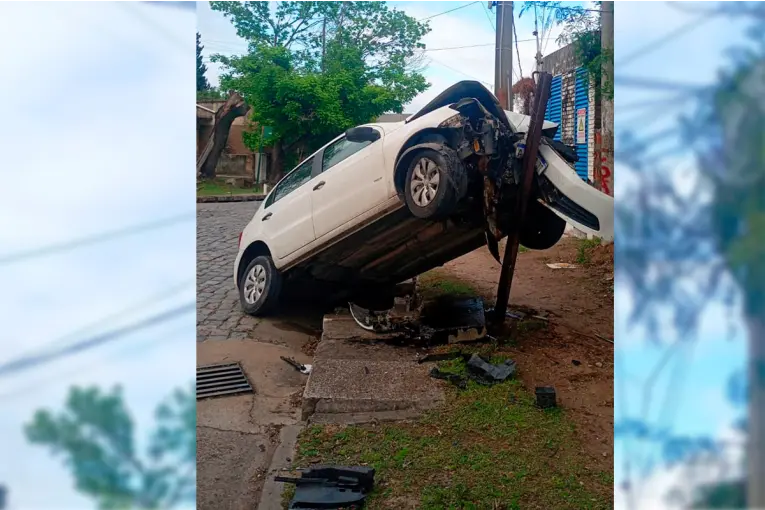 Joven conductora despistó y terminó con su auto “montado” sobre una estructura metálica